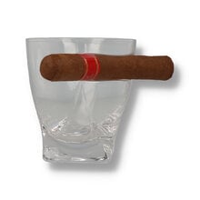 A whisky glass with a cigar resting on the cutout